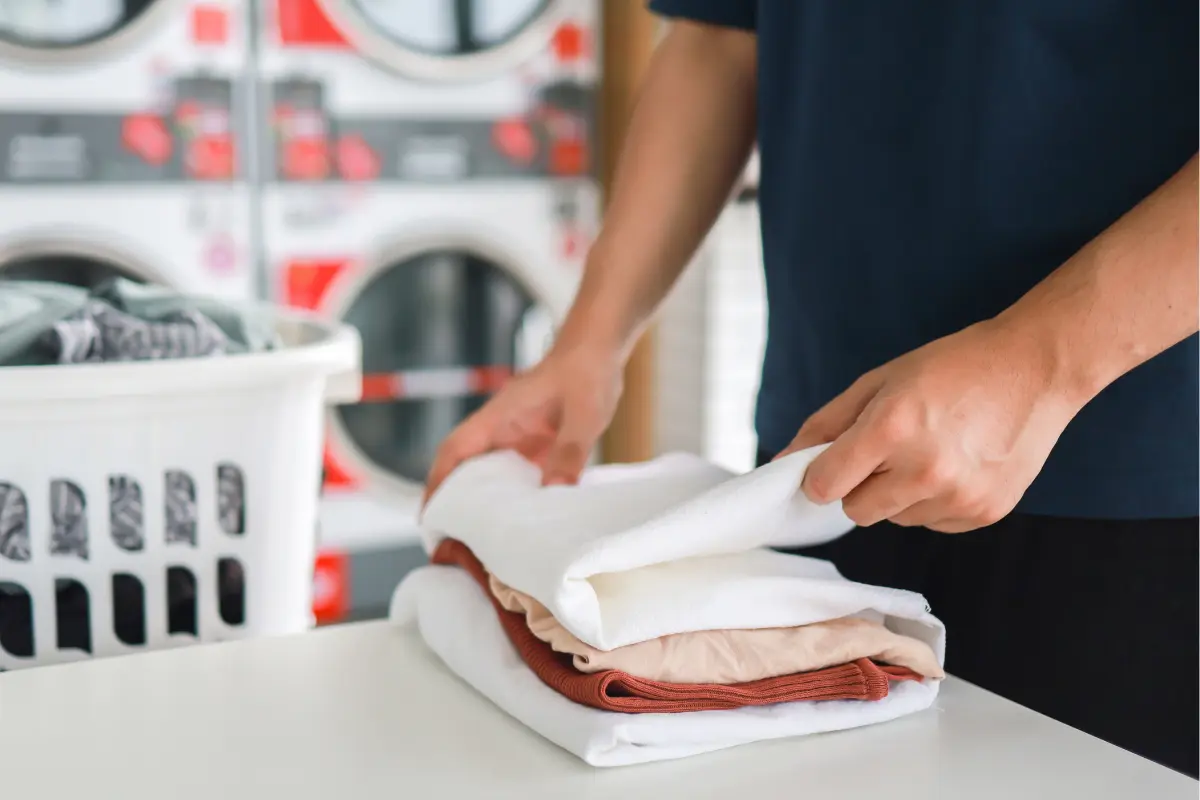 Professional cleaner folding laundry, dry cleaning vs. home washing
