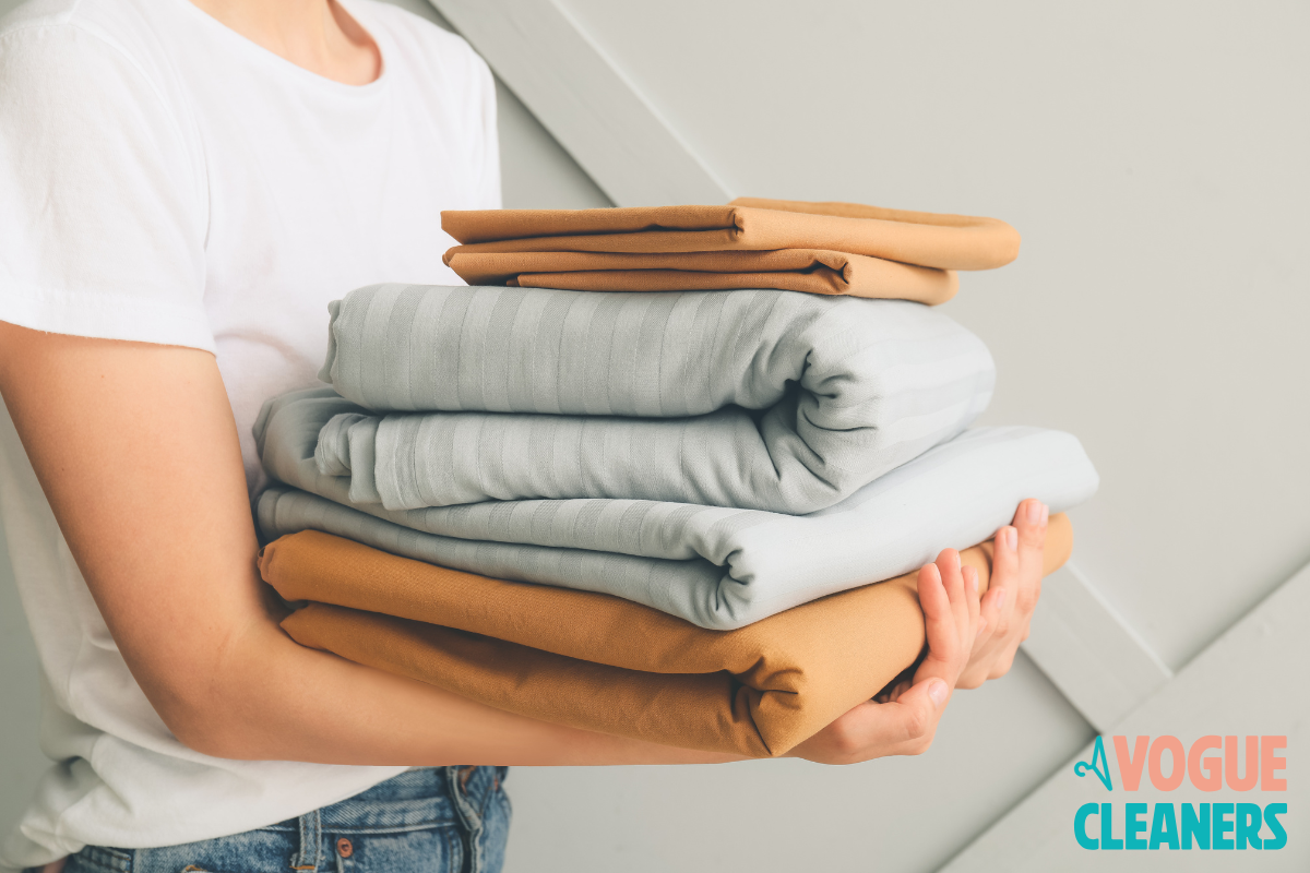 stack of folded comforters and guest bedding