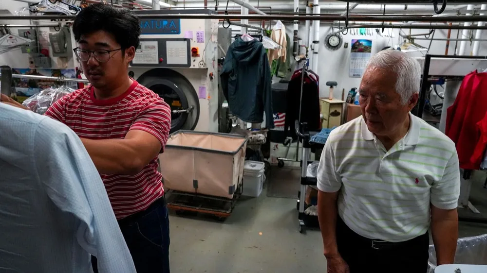 Enoch Ku and his father, Ha Wan Ku, working together at Vogue Cleaners.
